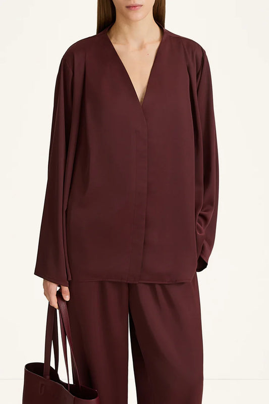 Person wearing a burgundy outfit with a plain background