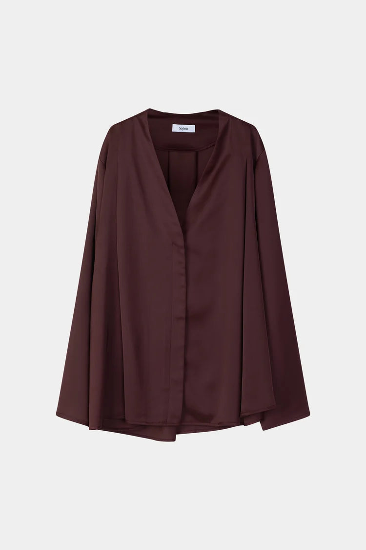 A dark brown, long-sleeved draped wrap jacket with a V-neckline, displayed on a neutral light gray background.