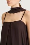 Brown sleeveless top worn by a person on a white background