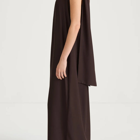 Brown halter neck dress worn by a model on a white background