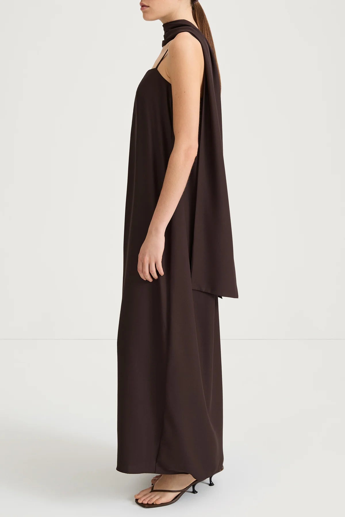 Brown halter neck dress worn by a model on a white background
