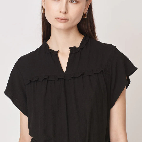 Short sleeved black top with notch neck and ruffle detail in a textured fabric