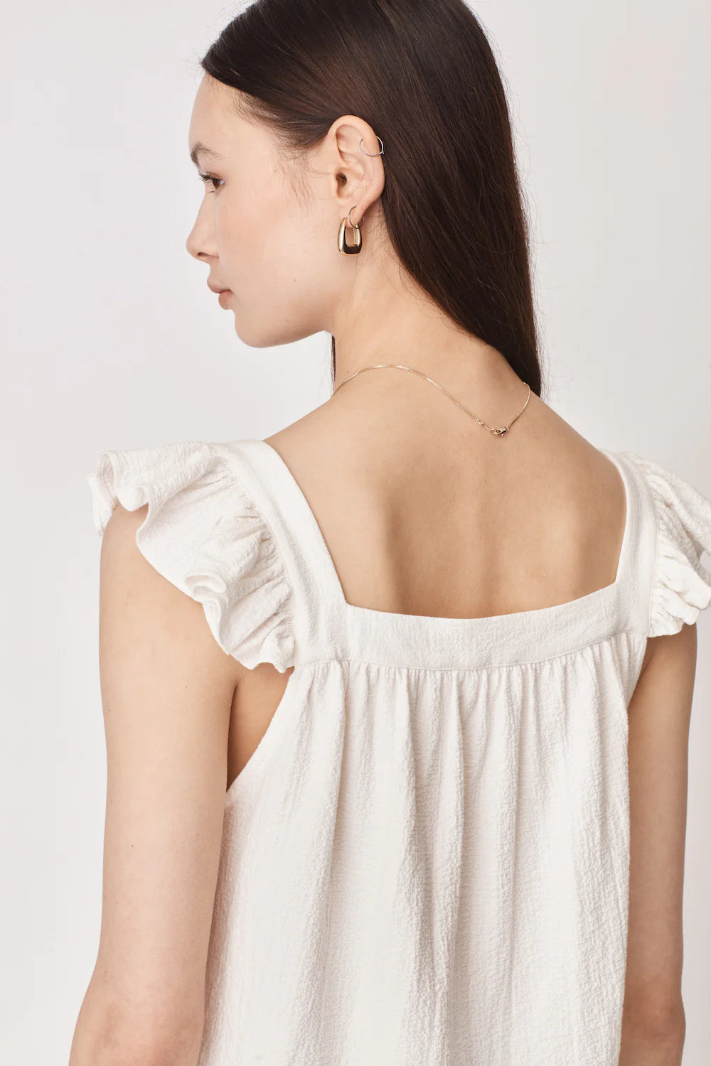 Ruffle capped sleeved top with square neck and backline in textured waffle like white ecru fabric