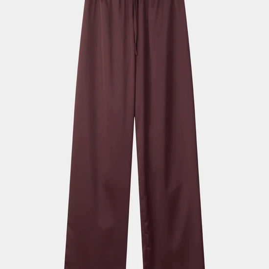 A pair of wide-leg trousers in a deep burgundy color, featuring an elastic waistband and a drawstring, shown flat against a light gray background.