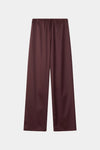 A pair of wide-leg trousers in a deep burgundy color, featuring an elastic waistband and a drawstring, shown flat against a light gray background.