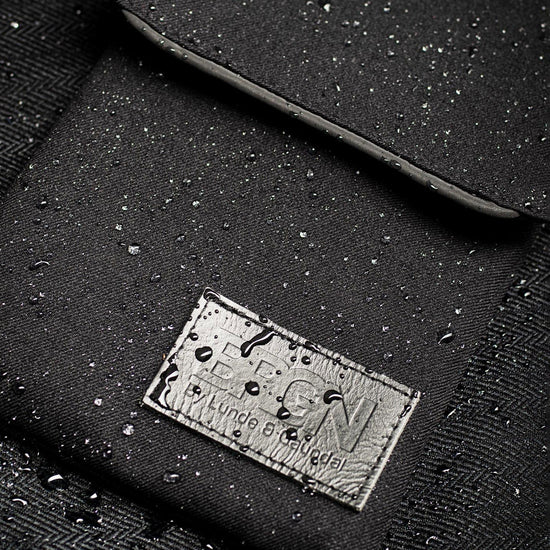 Close-up of a black waterproof bag with water droplets on its surface