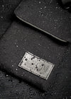 Close-up of a black waterproof bag with water droplets on its surface