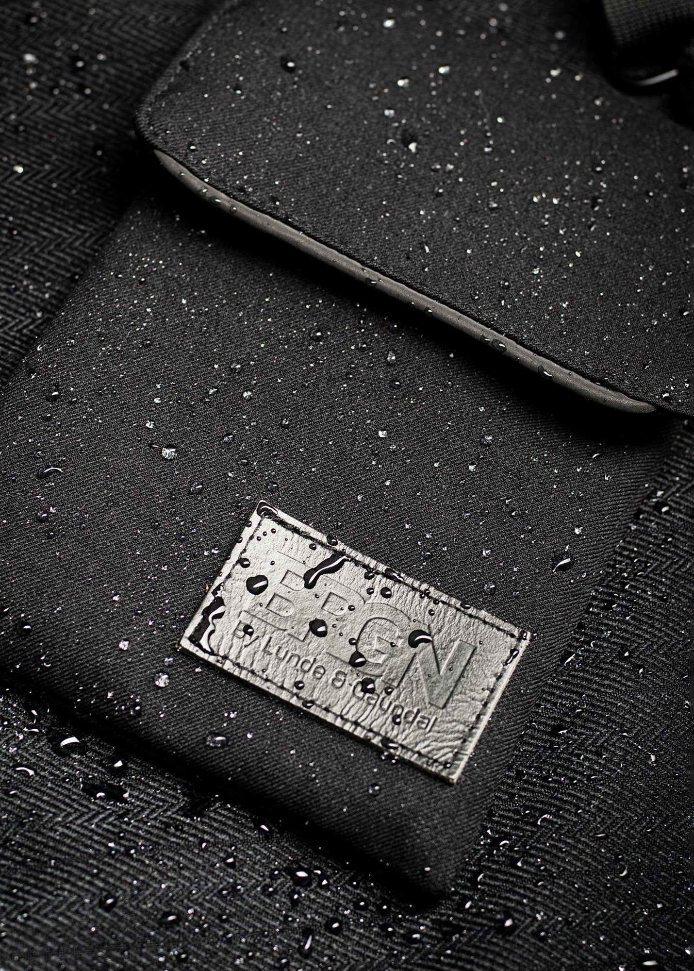 Close-up of a black waterproof bag with water droplets on its surface