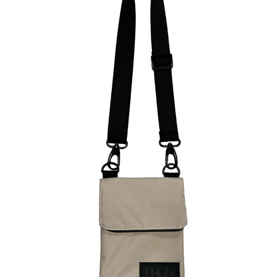 beige messenger purse with an adjustable black strap
