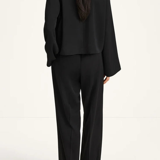 Person wearing a black suit on a white background