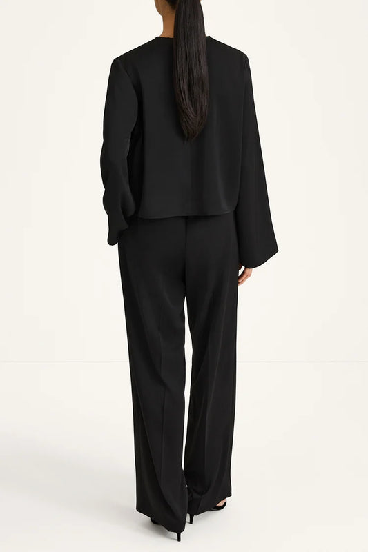 Person wearing a black suit on a white background