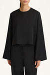 Person wearing a black outfit on a white background