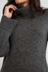 dark green roll neck jumper with ribbed cuffs, hem and neck with dropped shoulders  close up