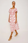 Woman wearing a red and white patterned dress on a plain background