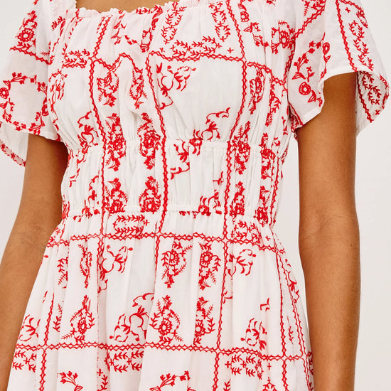 White dress with red floral pattern on a white background