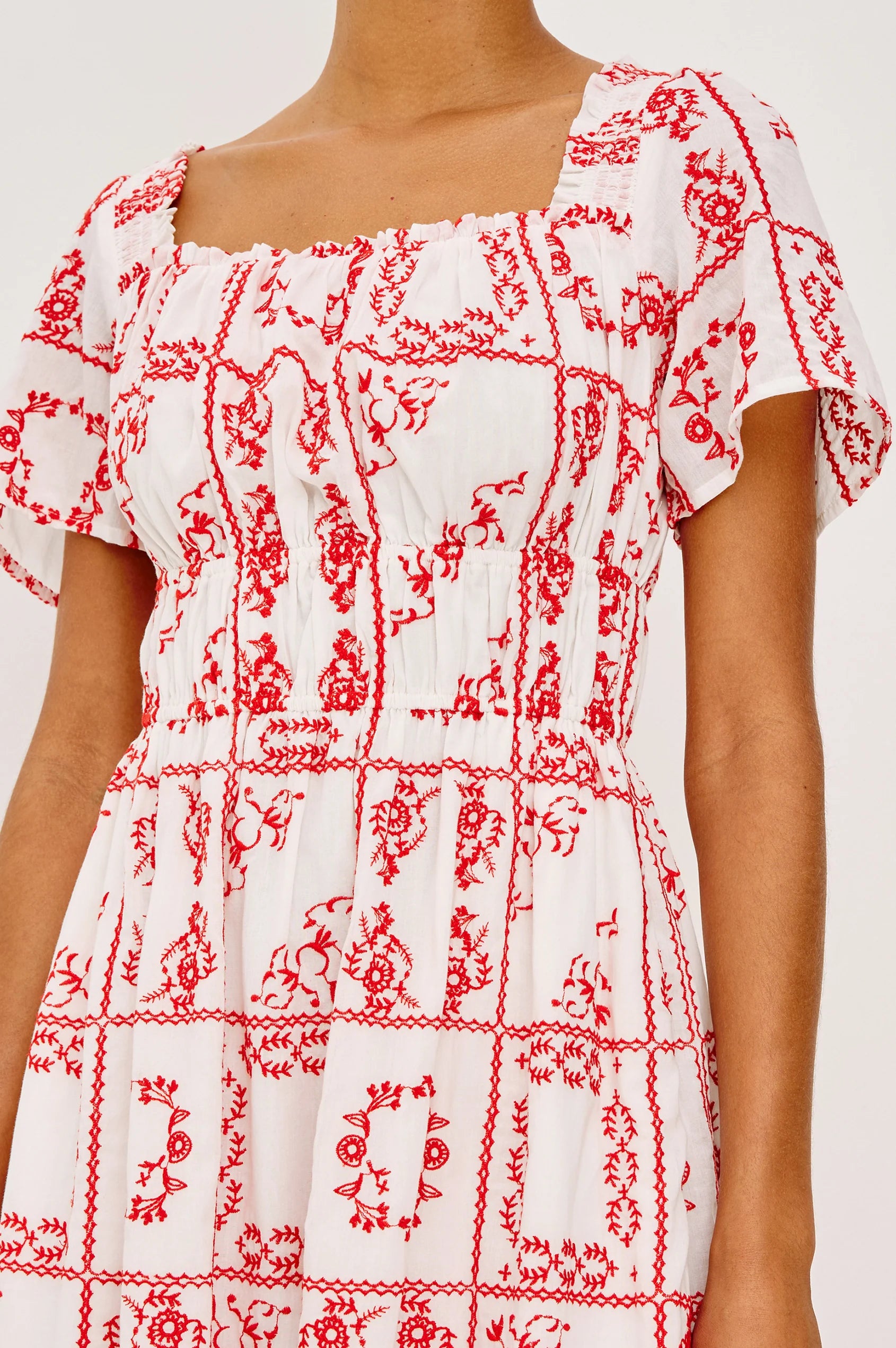 White dress with red floral pattern on a white background