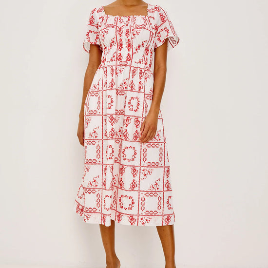 Woman wearing a red and white patterned dress on a white background