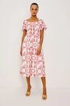 Woman wearing a red and white patterned dress on a white background