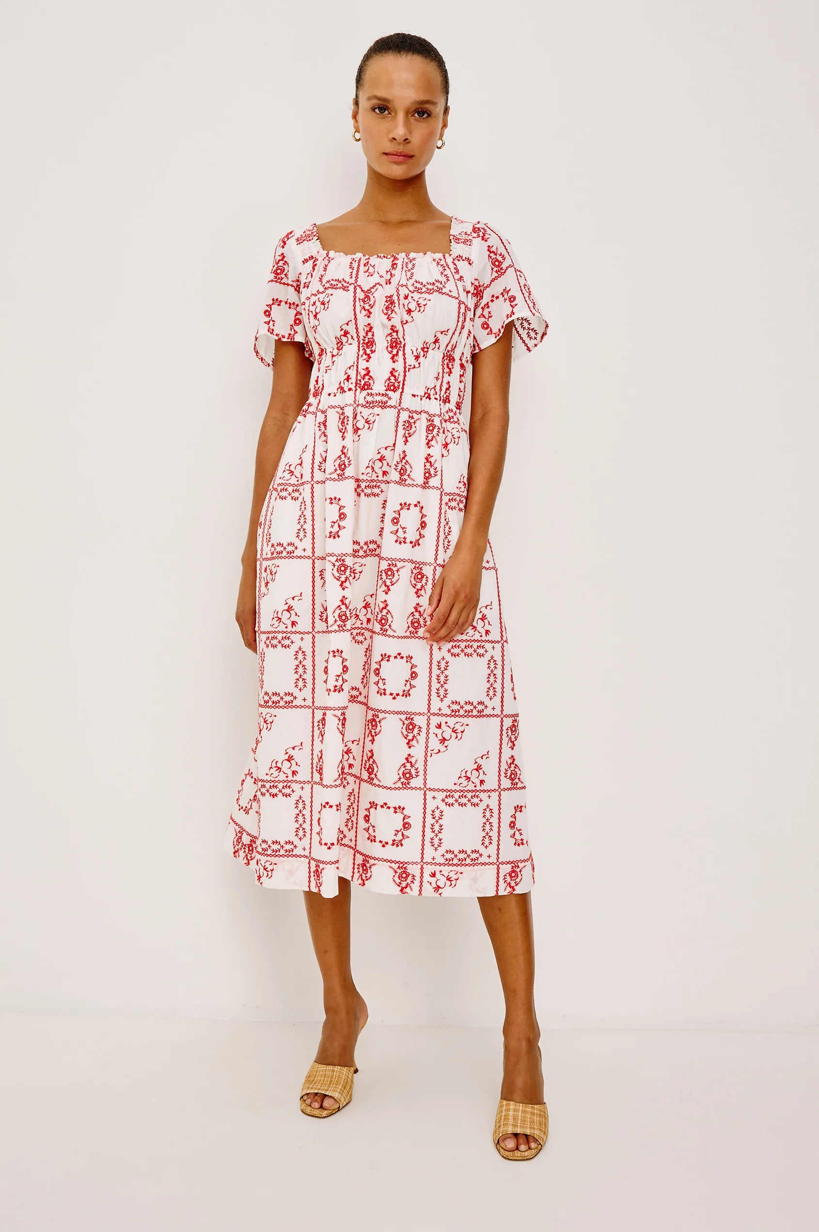 Woman wearing a red and white patterned dress on a white background