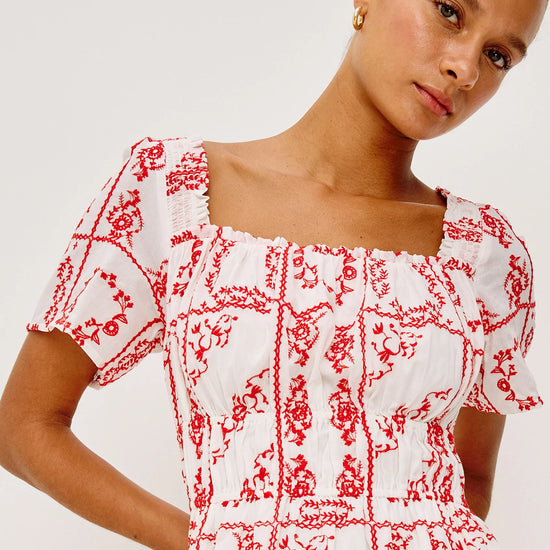 Close up of bodice of red and white embroidered dress