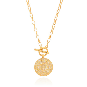 Gold necklace with toggle fastening and coin shaped pendant featuring dot work