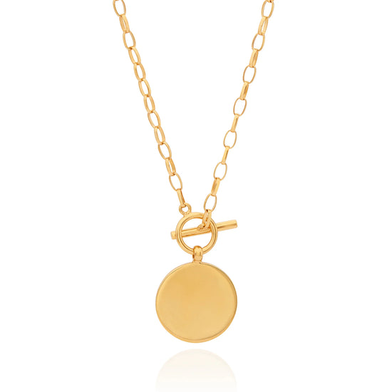 Gold necklace with toggle fastening and coin shaped pendant featuring dot work