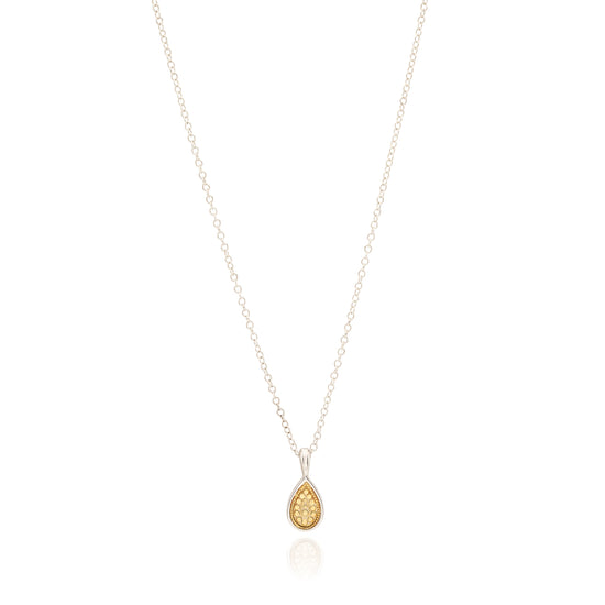 Gold teardrop pendant on a silver chain against a white background
