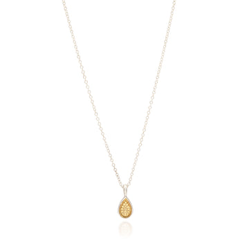 Gold teardrop pendant on a silver chain against a white background