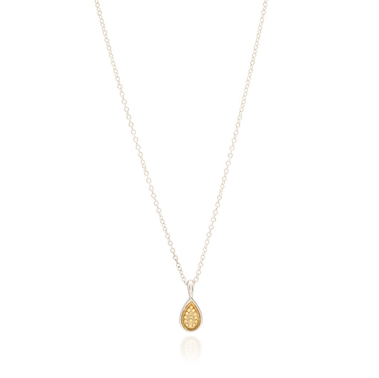 Gold teardrop pendant on a silver chain against a white background