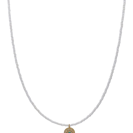 White beaded necklace with gold palted circle charm with turquoise charm
