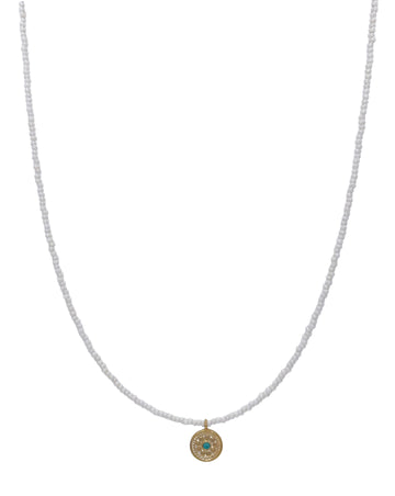 White beaded necklace with gold palted circle charm with turquoise charm