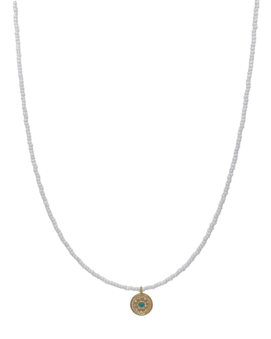 White beaded necklace with gold palted circle charm with turquoise charm