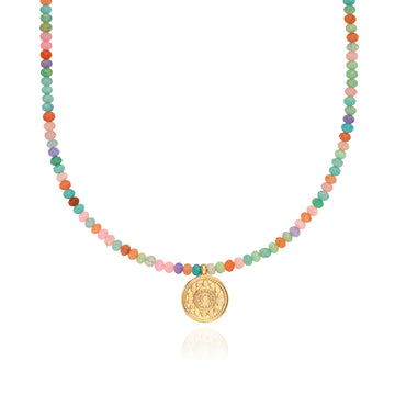 Necklace with multicolored beads and a gold pendant by Anna beck on a white background