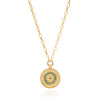 Gold necklace with a circular pendant featuring green stones on a white background