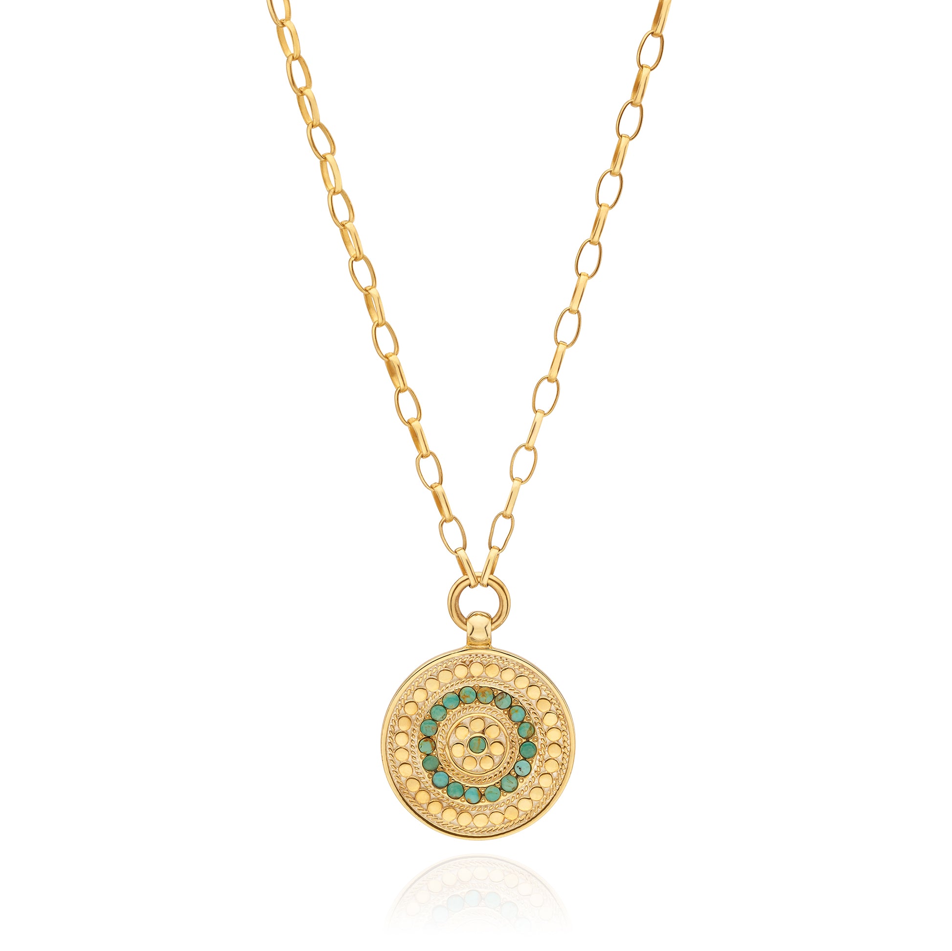 Gold necklace with a circular pendant featuring green stones on a white background