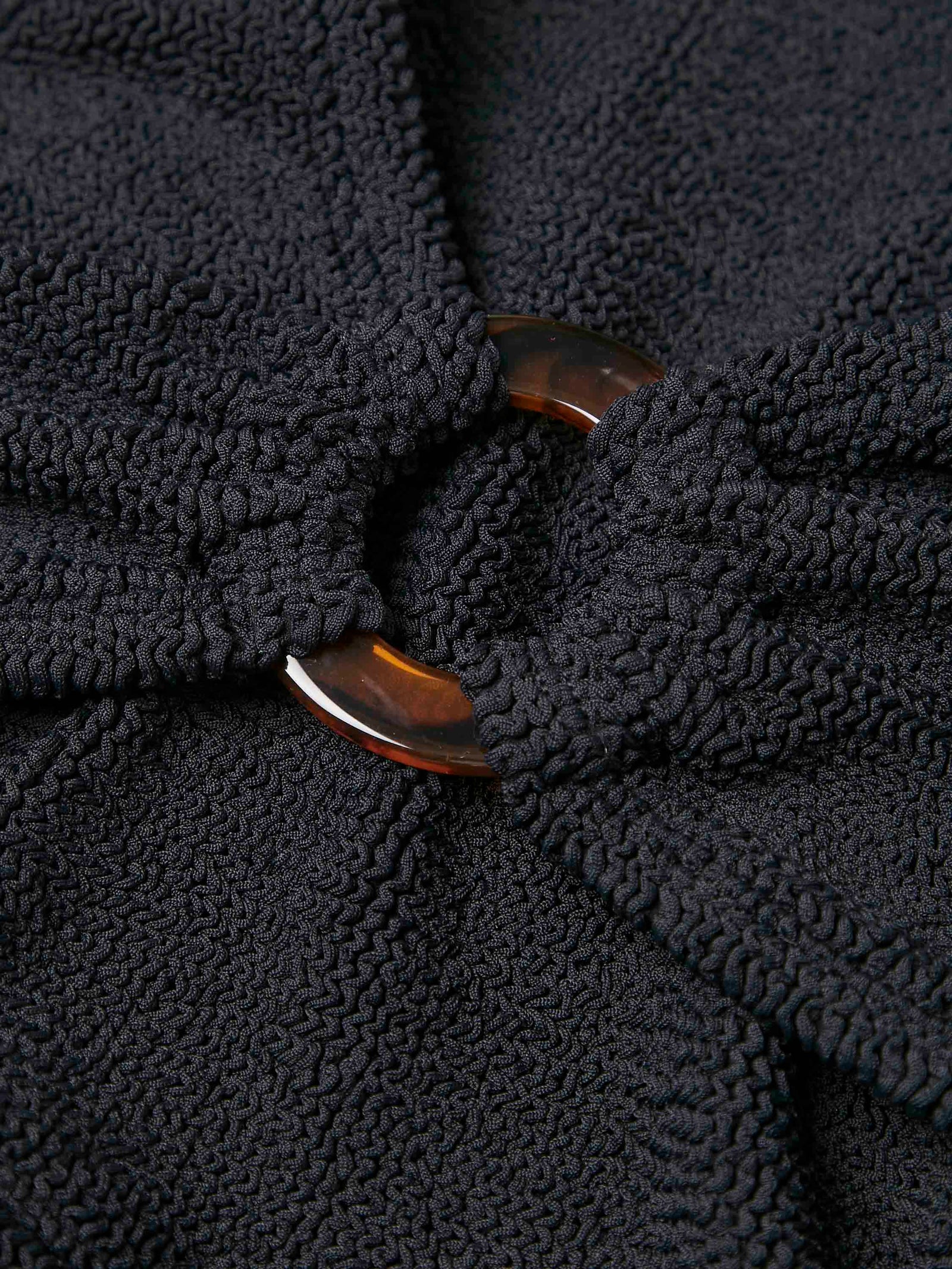 black crinkle bikini with hoop at the bust and high rise bottoms from hunza g close up of fabric