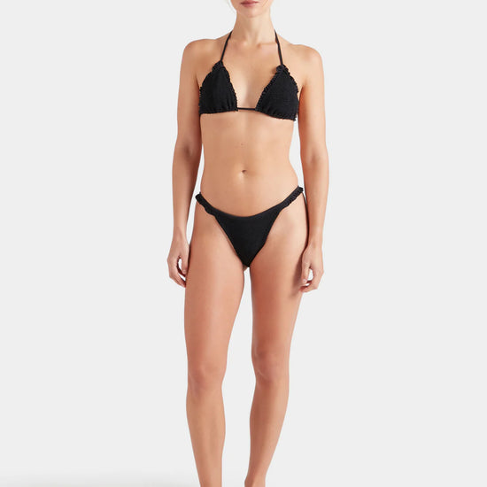 Woman wearing a black Hunza G bikini on a white background