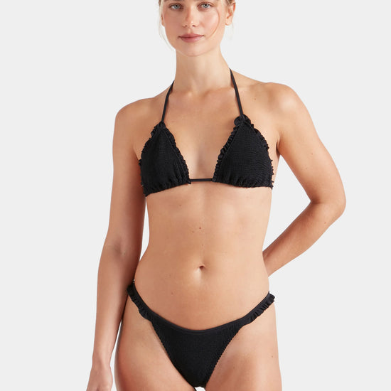 Woman wearing a black Hunza G bikini on a white background