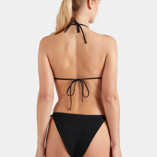 Woman wearing a black Hunza G bikini on a white background rear view
