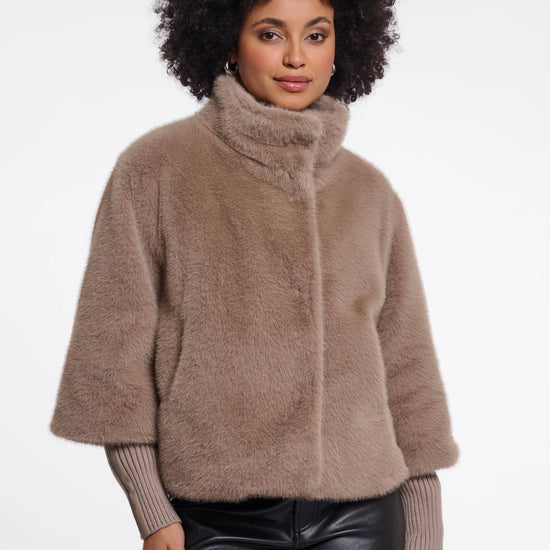 Woman wearing a brown fuzzy jacket on a white background