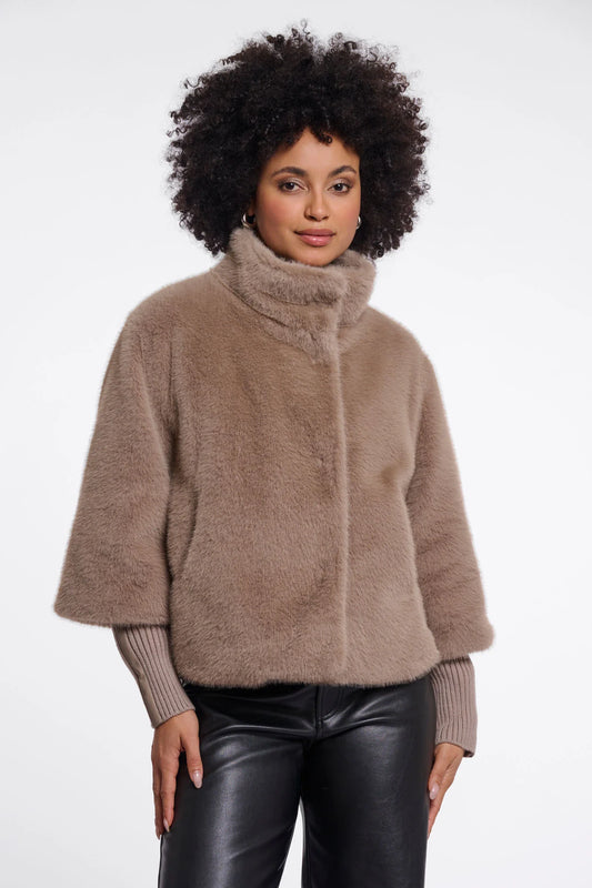 Woman wearing a brown fuzzy jacket on a white background