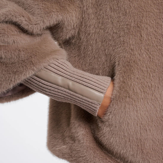 Close-up of a brown fuzzy sweater with a white background