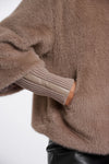 Close-up of a brown fuzzy sweater with a white background
