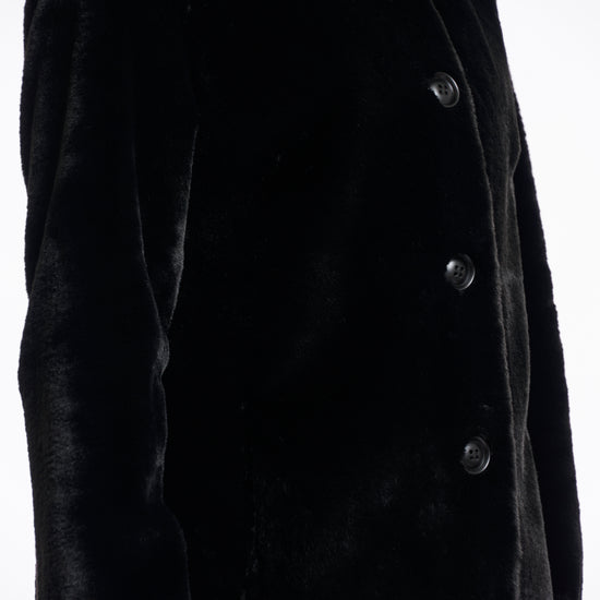 faux fur coat with high neck, black buttons and length just above the knee  side view 