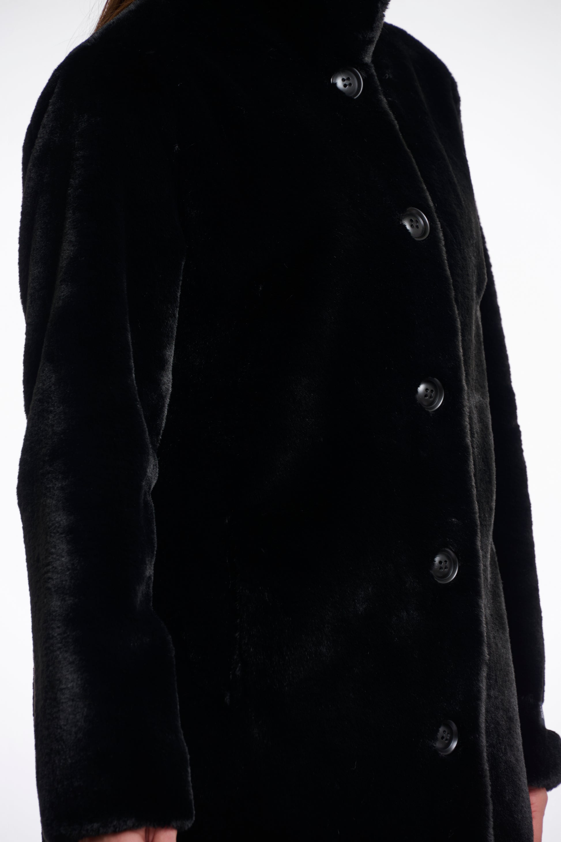 faux fur coat with high neck, black buttons and length just above the knee  side view 
