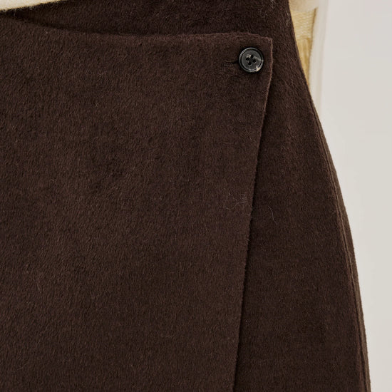 a close up image of the button fastening on a brown skirt 