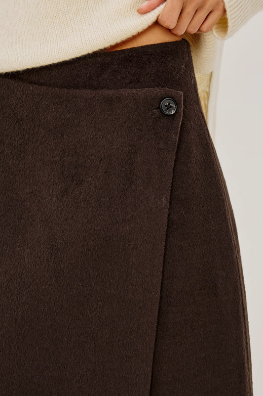 a close up image of the button fastening on a brown skirt 