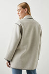 Light grey felt single breasted jacket with black chain stitching along the seams and edges with a patch pocket and brown tortoiseshell large buttons