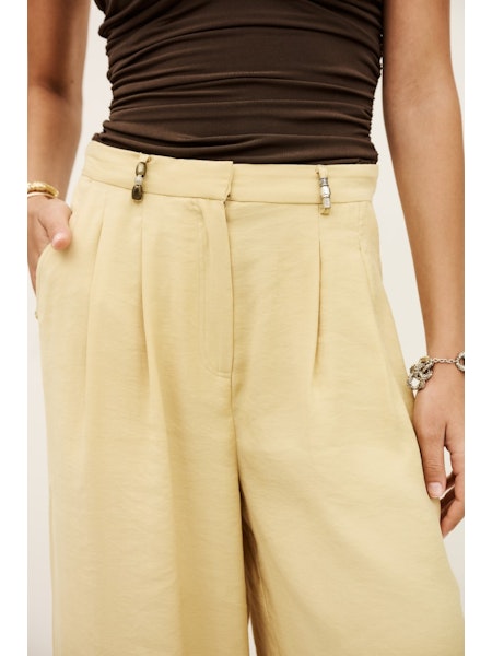 Detail image of straw coloured trousers with bead details