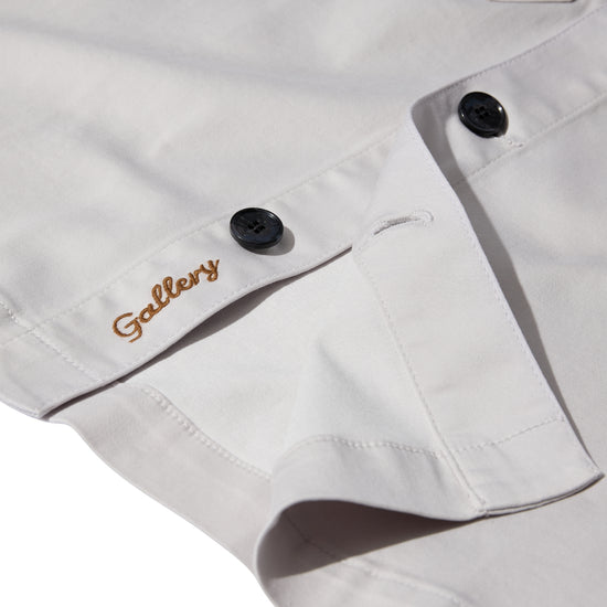 mens light grey cotton overshirt with black buttons and chest pockets close up